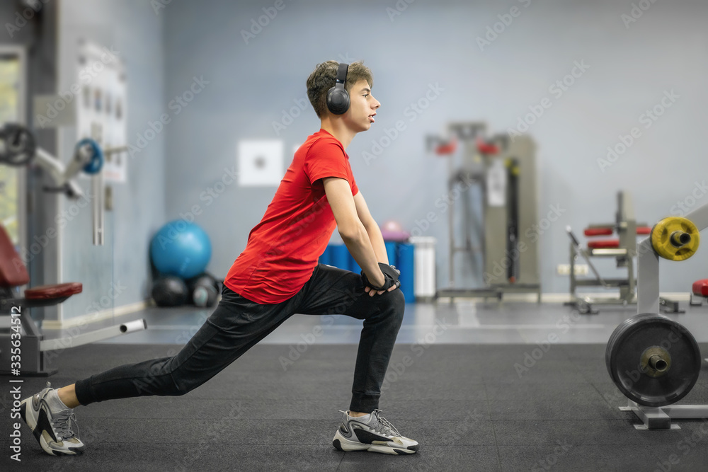 young man in sports clothes and headphones is engaged in the gym young man in sports clothes and headphones is engaged in the gym
