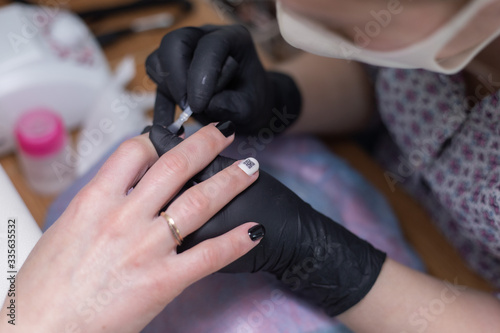 Manicurist at work  girl doing manicure  masked