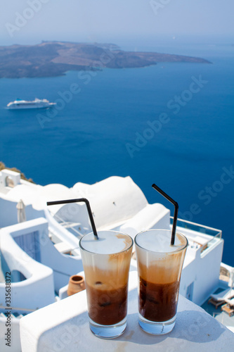 Two glasses of cold coffee in Santorini island. Traditional Greek Freddo cappuccino and sea view. photo