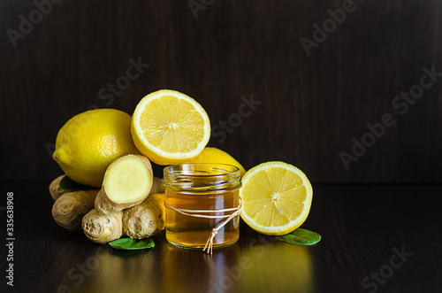 honey, lemon, ginger for boosting immunity for colds, flu, epidemic on dark wooden background with copy space, soft focus