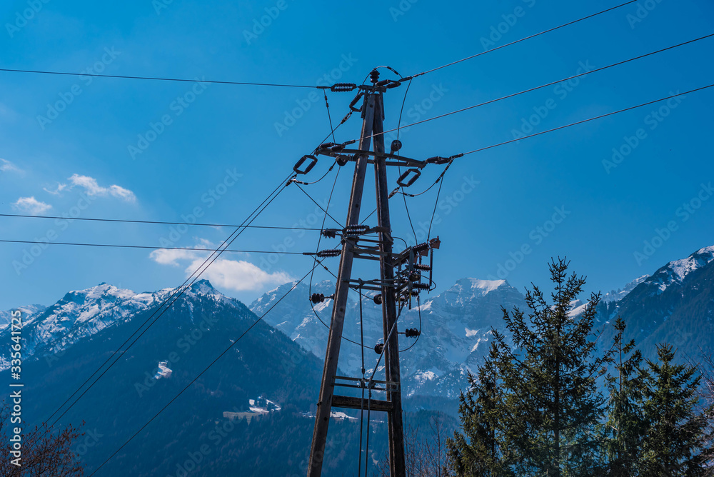 Strommast aus Holz mit Bergpanorama