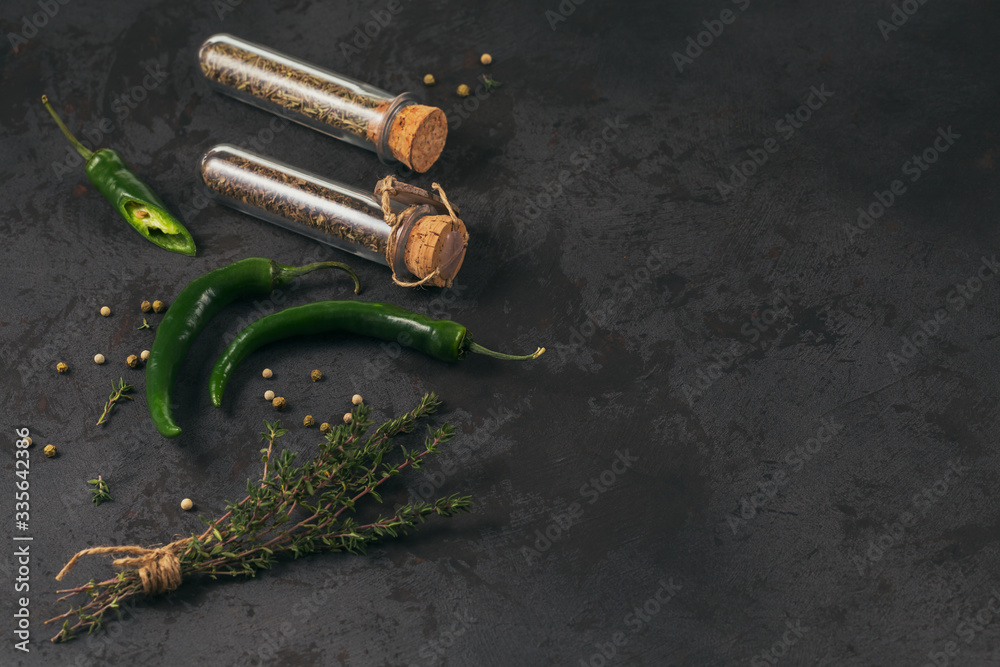 Assorted spices and herbs on dark black background