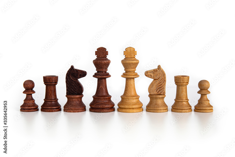 Wooden chess pieces aligned on a white background. Picture taken in studio with lightbox. Wooden chess pieces aligned on a white background. Picture taken in studio with lightbox.