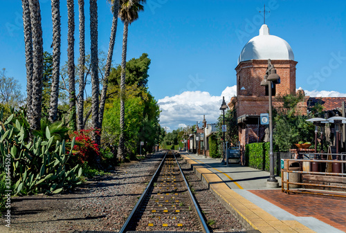 A single set of train tracks leads to a vanishing point on the horizon at the San Juan Capistrano train station.