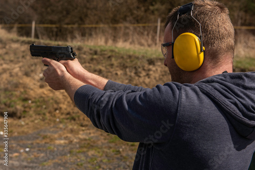 man with hand gun pistol aiming at target military police traingin sport shooting hunting photo