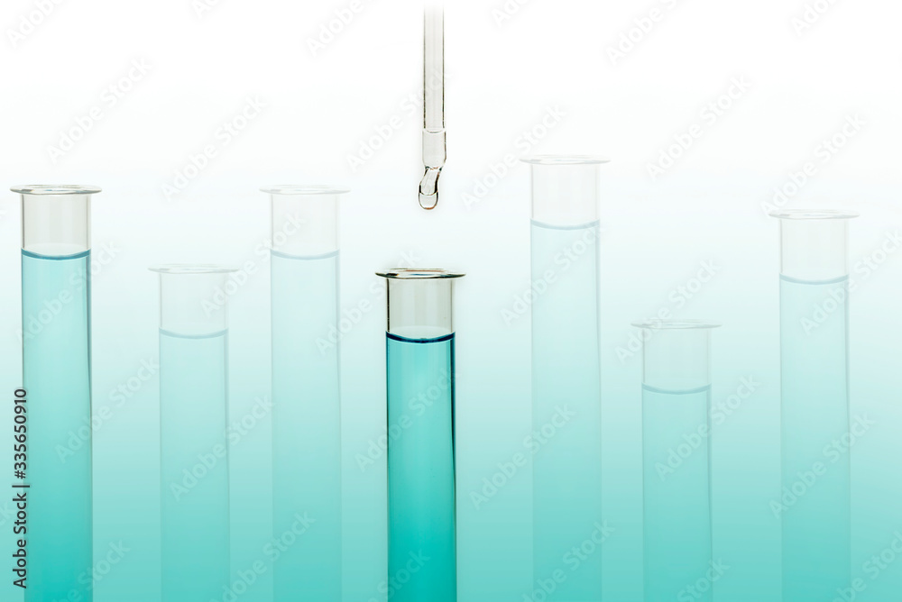 Dripping reagent into test tube with liquid sample Dripping reagent into test tube with liquid sample
