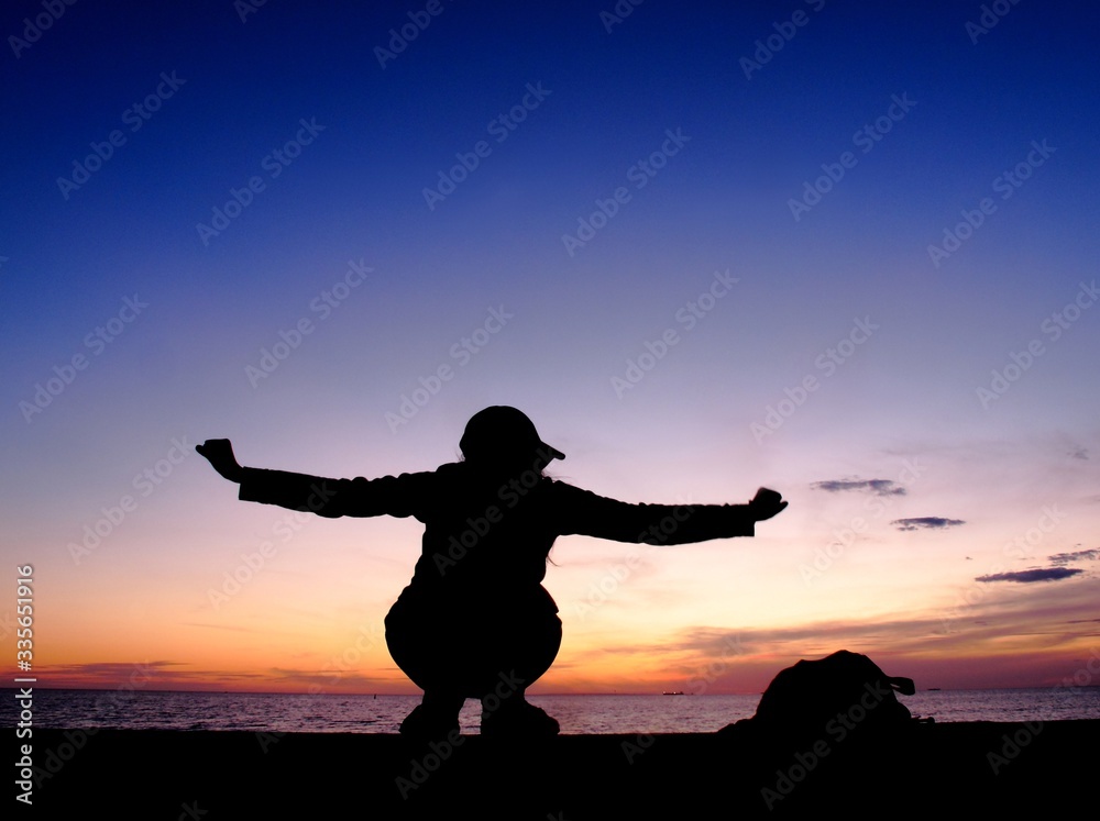 silhouette woman sit at sea , sunset light