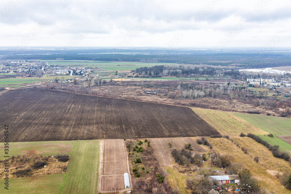 Nowy Dwor, Poland above view from window near airport with rural winter brown plowed landscape countryside town village near Warsaw and farm fields greenhouse