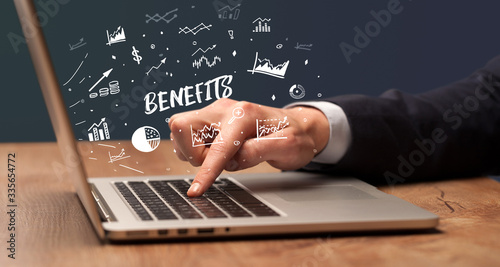 Businessman working on laptop with BENEFITS inscription, modern business concept