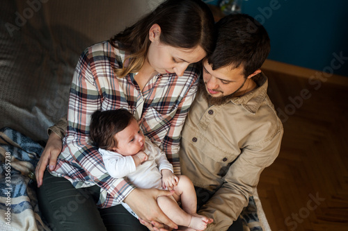 Lovely family of young parents and baby at home