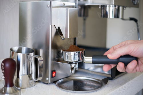 Grind coffee into the portafilter of the espresso machine.