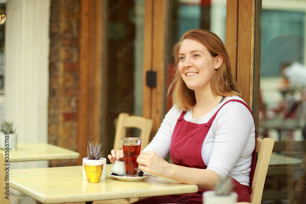 young woman enjoying a cup of tea at a cafeteria young woman enjoying a cup of tea at a cafeteria