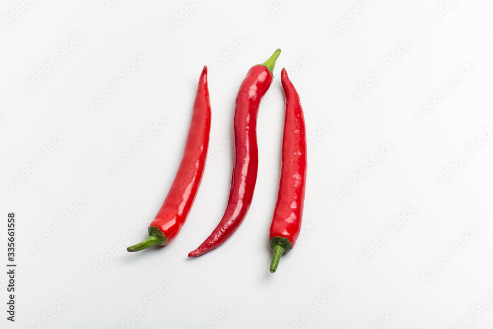 Juicy red hot chili peppers on a white background, folded in a row