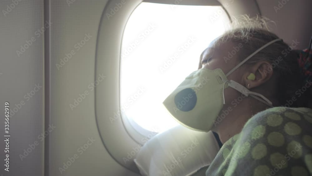 Woman travel caucasian at plane with wearing protective medical mask. Girl tourist at aircraft