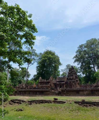 Ruins of Angkor, temple of Banteay Srei, stone pyramids with tree on grass, Angkor Wat, Cambodia