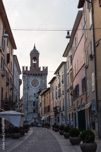 Typical street in Brescia Old Town with Torre della Palata on background, Lombardy, Italy.