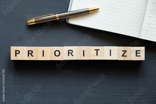 Modern business buzzword - prioritize. Top view on wooden table with blocks. Top view. photo