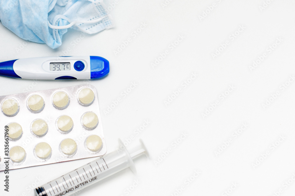 Obraz premium Facial protective mask, syringe, thermometer and pills. Flat lay and copy space concept. Pharmacy theme.