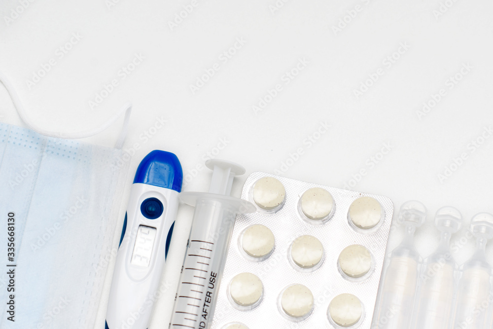 Pills, thermometer and syringes on white background. Coronavirus (COVID-19) epidemic. Flat lay, top view, copy space. Pills, thermometer and syringes on white background. Coronavirus (COVID-19) epidemic. Flat lay, top view, copy space.
