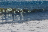 Solar glare in the form of stars on the sea wave. Sparkling sea waves during the surf.