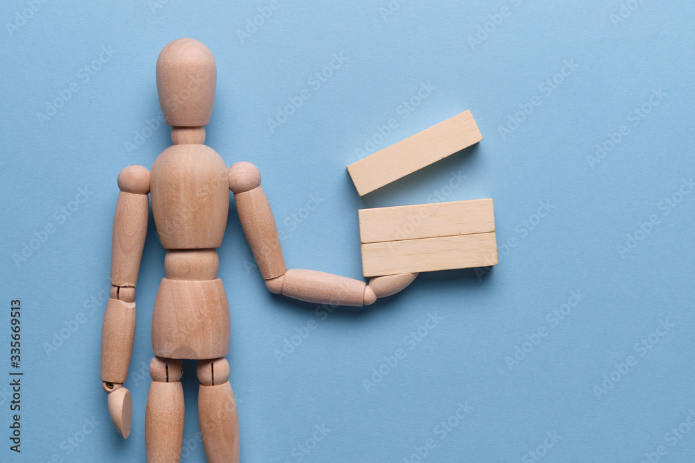 The concept of preparing business reports. Wooden blocks holds a mannequin on a blue background. The concept of preparing business reports. Wooden blocks holds a mannequin on a blue background.