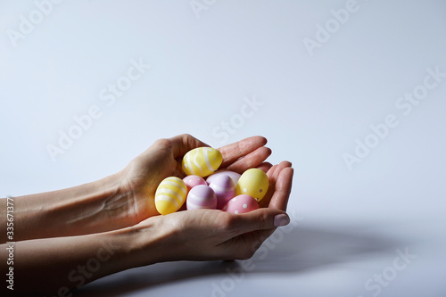 Hands holding modern painted easter eggs.