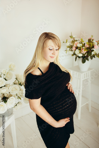 Pregnant girl with a big belly in a studio room