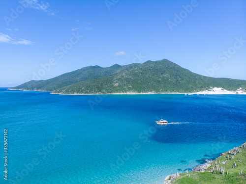 Vista de drone de barco entre ilhas no mar paradisíaco de Arraial do Cabo, Rio de Janeiro, Brasil