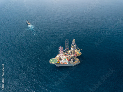 Aerial view offshore jack up rig and a tow vessel at the offshore location