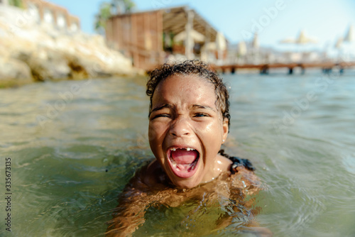 Little girl in danger drowning at the ocean.