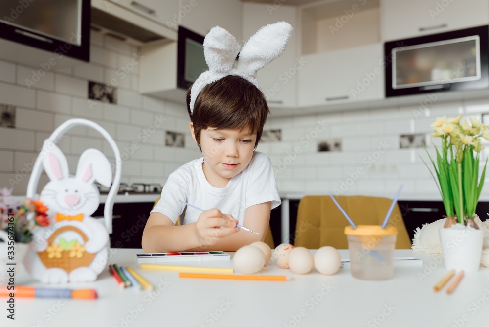 Cute little boy painting Easter eggs. Happy child with Easter eggs Cute little boy painting Easter eggs. Happy child with Easter eggs