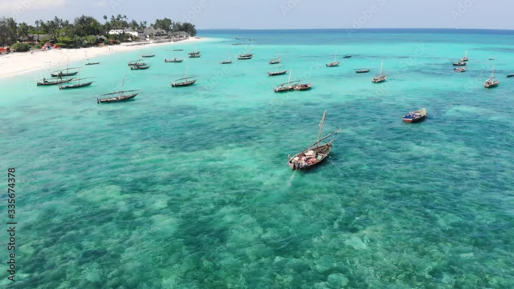 Aerial Drone shot on Traditional Unguja Dhow boats near the Beautiful tropical coast line at Zanzibar. Nungwi beach in a day time with blue turquoise Indian ocean