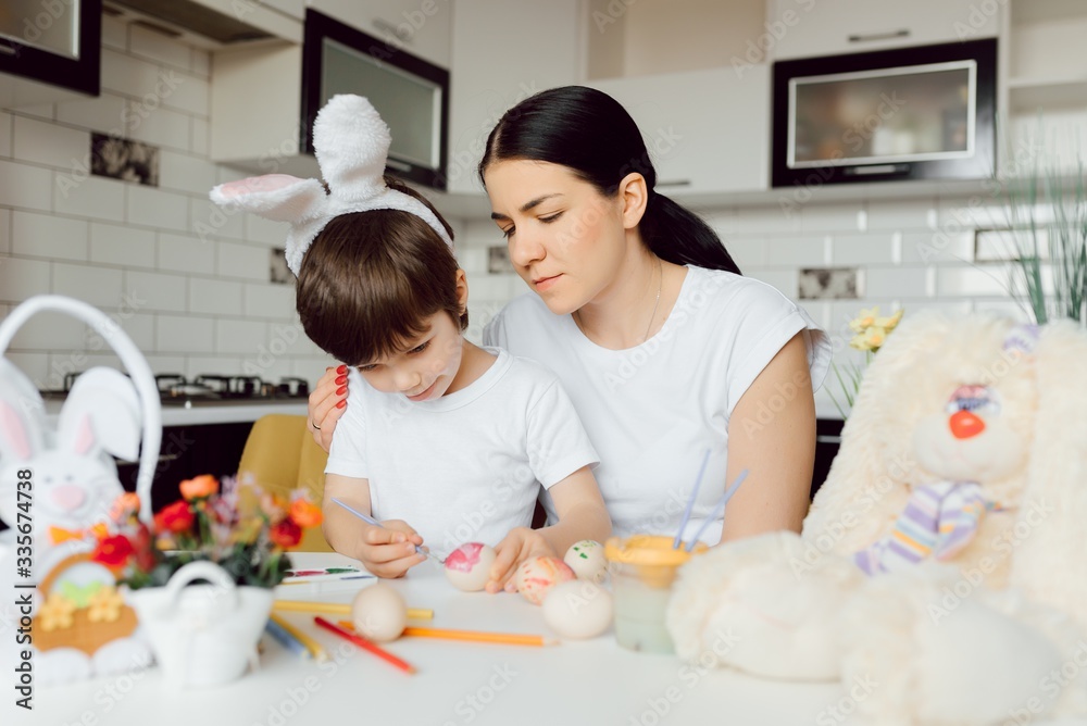Mother with kid painting easter eggs at home Mother with kid painting easter eggs at home