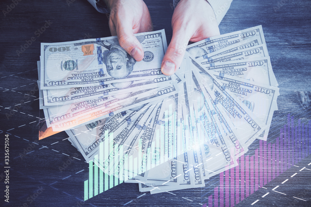 Multi exposure of financial graph drawing hologram and USA dollars bills and man hands. Analysis concept. Multi exposure of financial graph drawing hologram and USA dollars bills and man hands. Analysis concept.