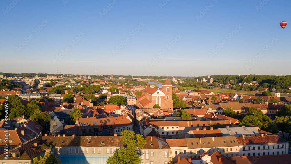 Beautiful panoramic aerial view photo from flying drone on to Kaunas Franciscan Xavier Church and Kaunas City Hall with flying balloons in the background sky. Kaunas, Lithuania (series)