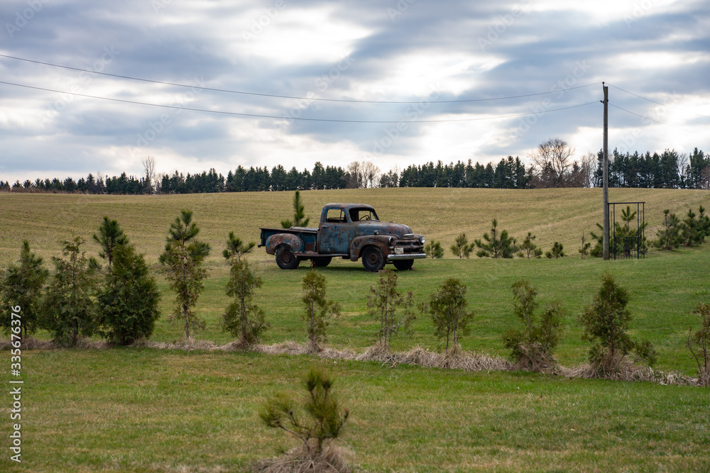 Fototapeta premium Old historic rusty truck in the field with cloudy skies