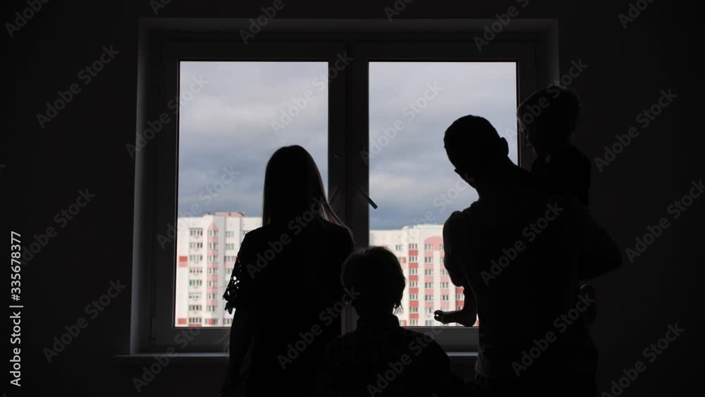 Silhouette of a large family on the background of a window in a new apartment. Silhouette of a large family on the background of a window in a new apartment.