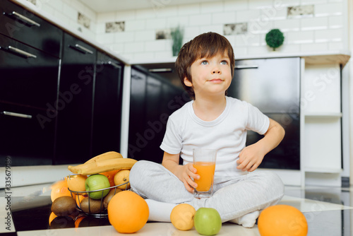 Little boy in the kitchen with a bowl of fresh fruits