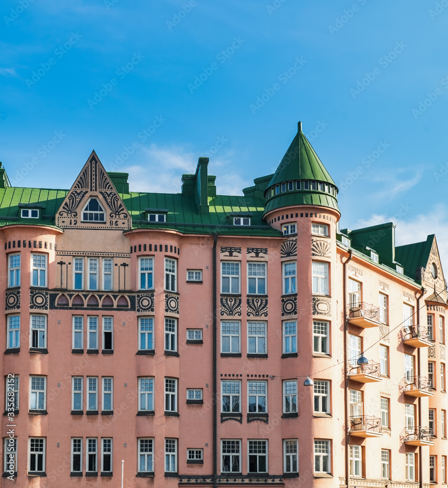 Obraz premium Beautiful architecture in Agricolankatu Street, Finnish house in Kallio district - historical center of Helsinki, Finland. Sunset time, facade view