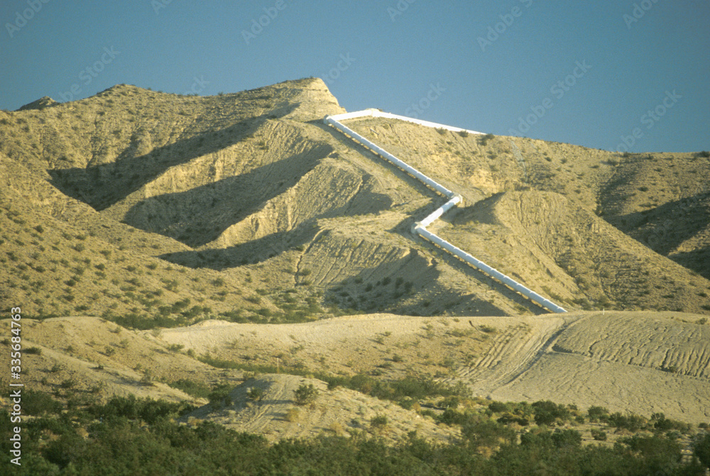 An aqueduct which supplies water to Los Angeles winding down a hill in the California desert