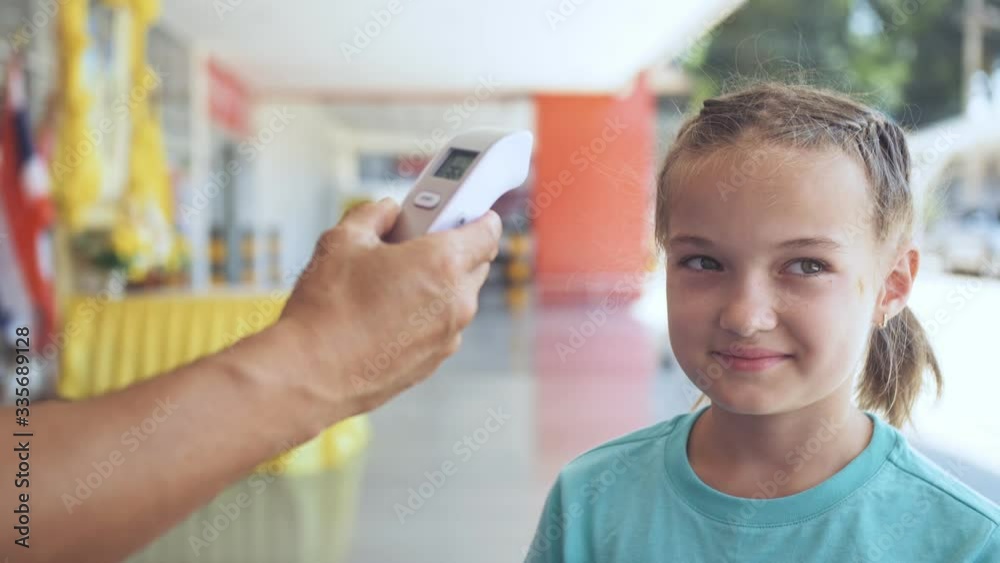 Temperature check at a supermarket of little girl, grocery store with