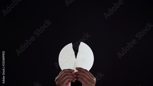 Hands of priest raising a divided sacramental bread photo