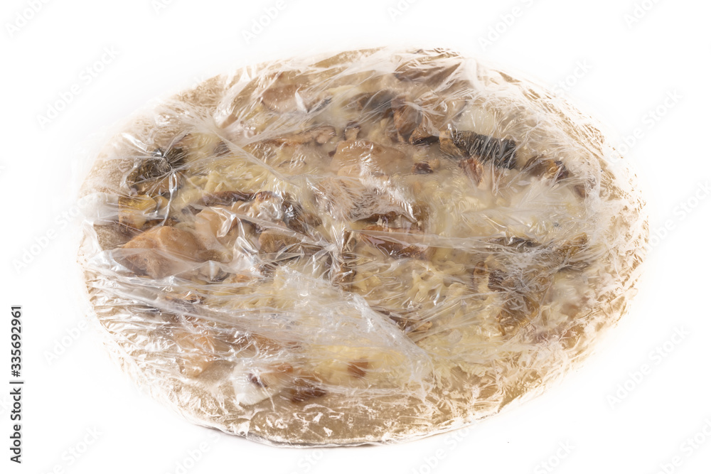 Frozen pizza wrapped in plastic isolated on a white background. Frozen pizza wrapped in plastic isolated on a white background.