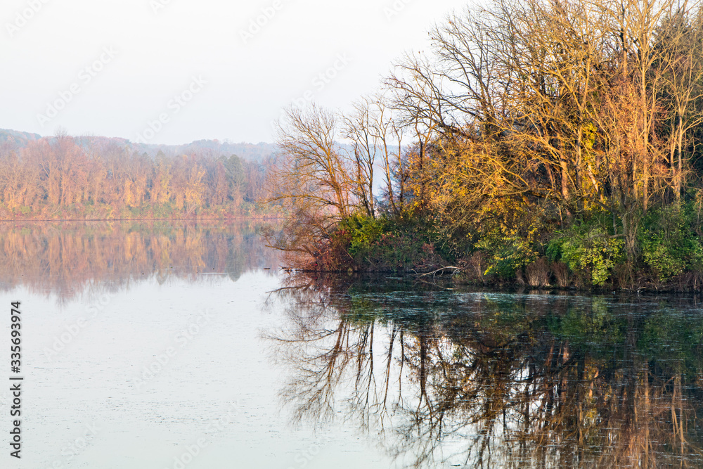 Fototapeta premium Autumn landscape featuring colorful trees reflecting in a lake in eastern Pennsylvania
