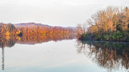 Panoramic autumn landscape featuring colorful trees reflecting in a lake in eastern Pennsylvania photo