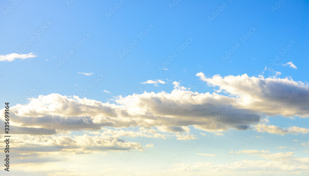 Beautiful puffy clouds at sunset isolated against pastel blue skies
