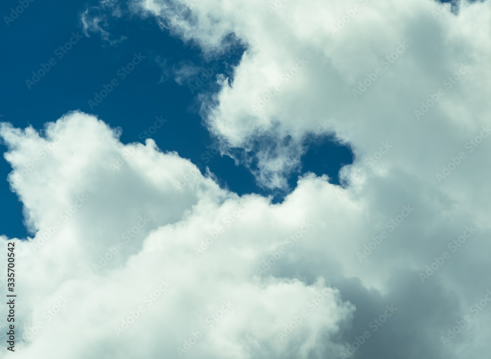 Beautiful puffy clouds at sunset isolated against pastel blue skies Beautiful puffy clouds at sunset isolated against pastel blue skies