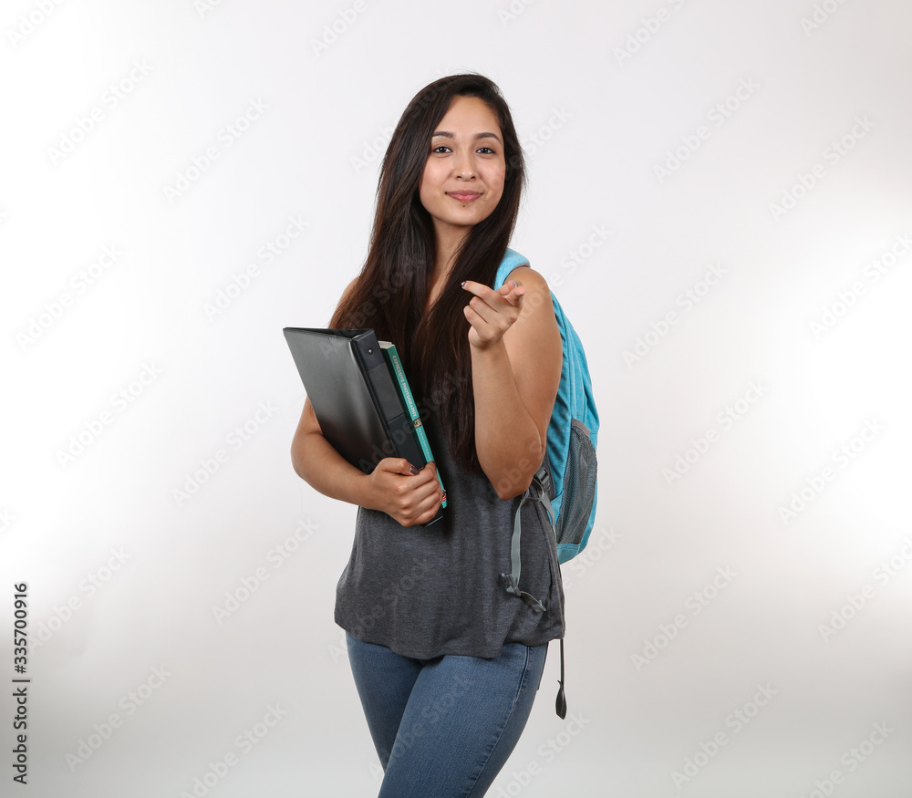 Female Student Points As She Holds Books Female Student Points As She Holds Books