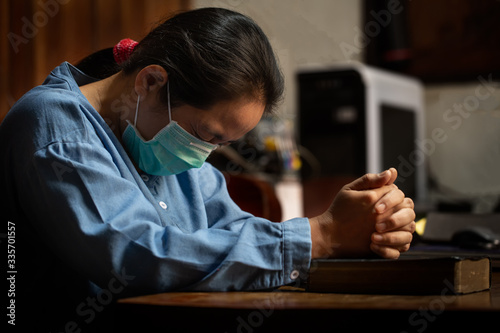 Asian woman wearing medical mask and praying
