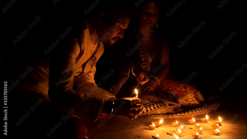 Vidéo Stock Beautiful Indian Gujarati couple in Indian traditional dress lightening Diwali diya